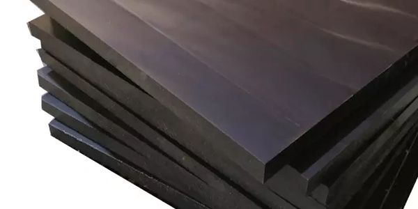 Stack of black rectangular sheets with smooth surfaces.