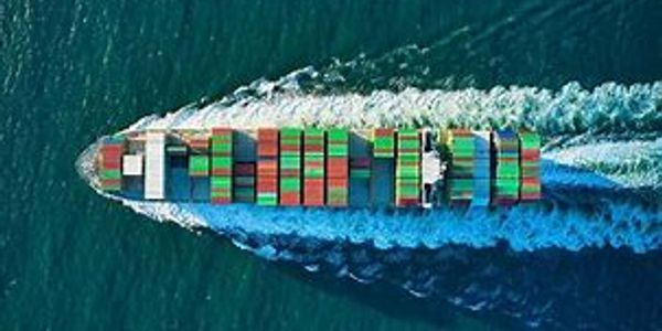 A large container ship carrying colorful cargo containers at sea.