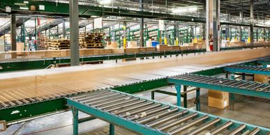 Empty conveyor belts in a large, organized warehouse or distribution center.