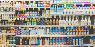Supermarket shelves stocked with various dairy and non-dairy milk products.