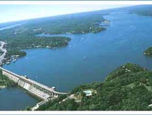 A blue lake and the dam with water cascading over it