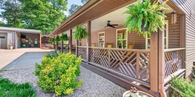 Charming porch with hanging plants and wooden railing.