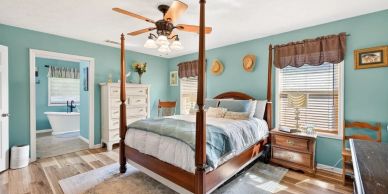 Cozy bedroom with a four-poster bed and adjoining bathroom.
