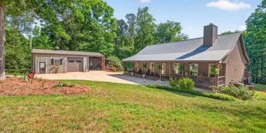 A cozy house with a detached garage in a green yard.