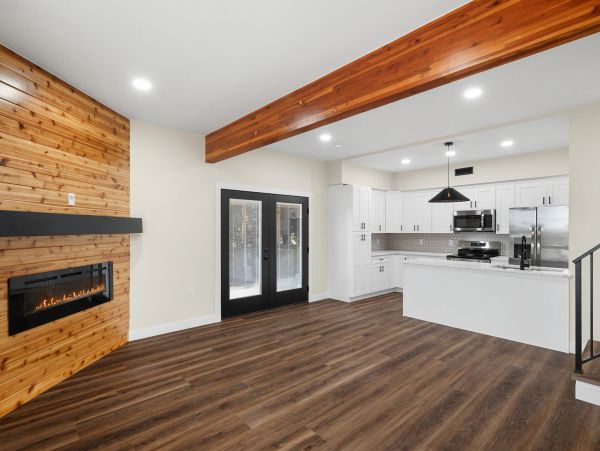 Modern open living room with wooden floor and kitchen.