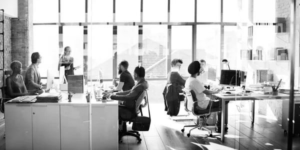 Team meeting in a modern office with large windows and natural light.