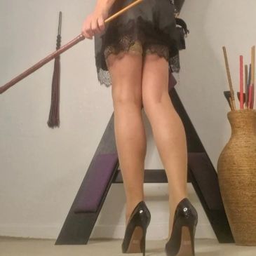 Person in black heels standing near a large black letter A.