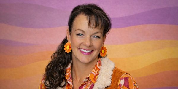 Dr. Jenni Emery of The Merc Centers LLC in a retro-inspired portrait wearing colorful 1970s flower 