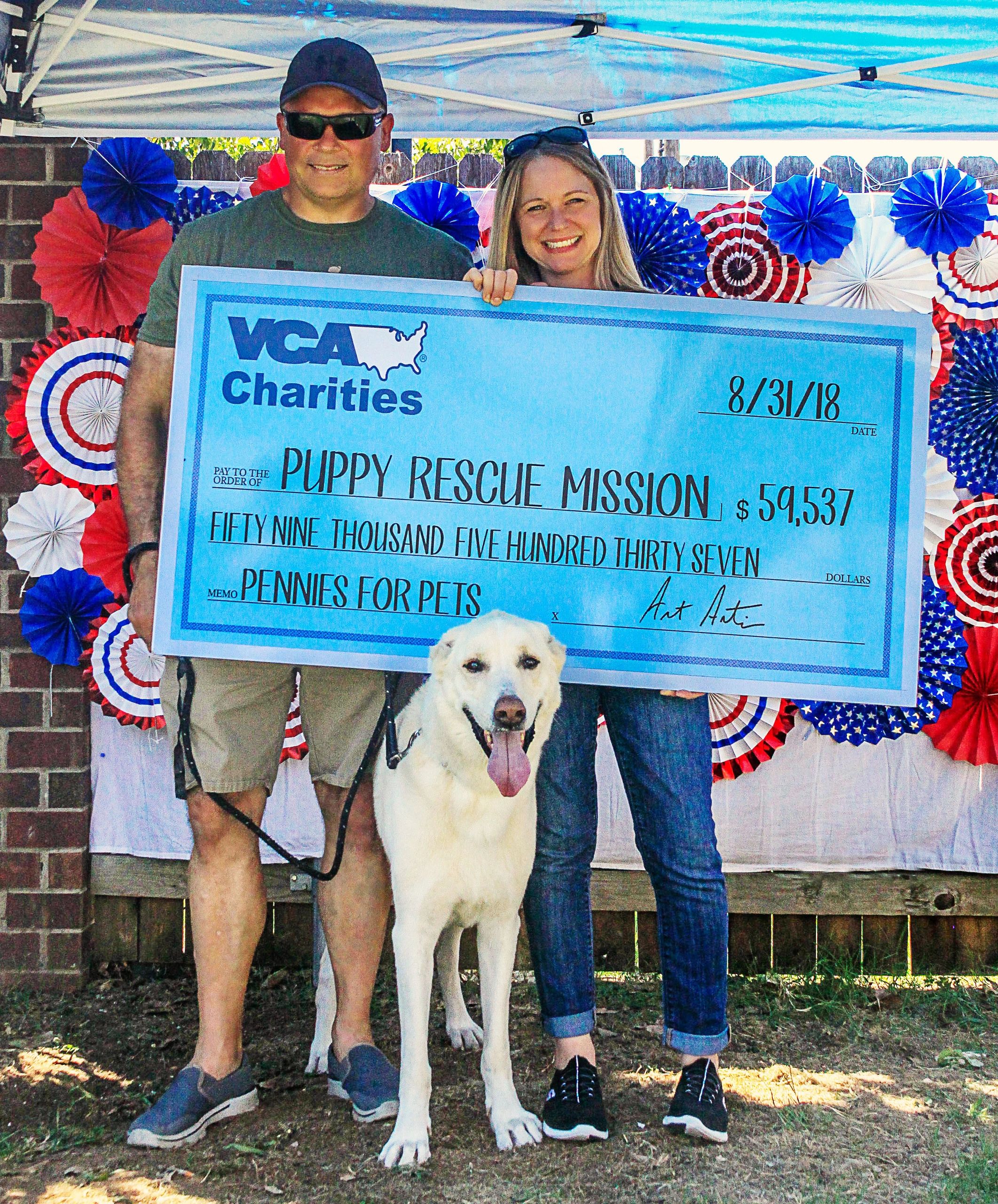 David Small and woman and dog holding large check