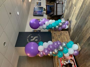 Colorful balloon pillars decorate a cozy indoor space.