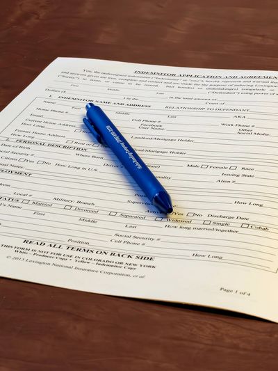 Bail bond application on a desk with a pen.