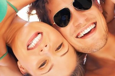 Smiling couple showing bright white teeth after tooth coloured filling treatment