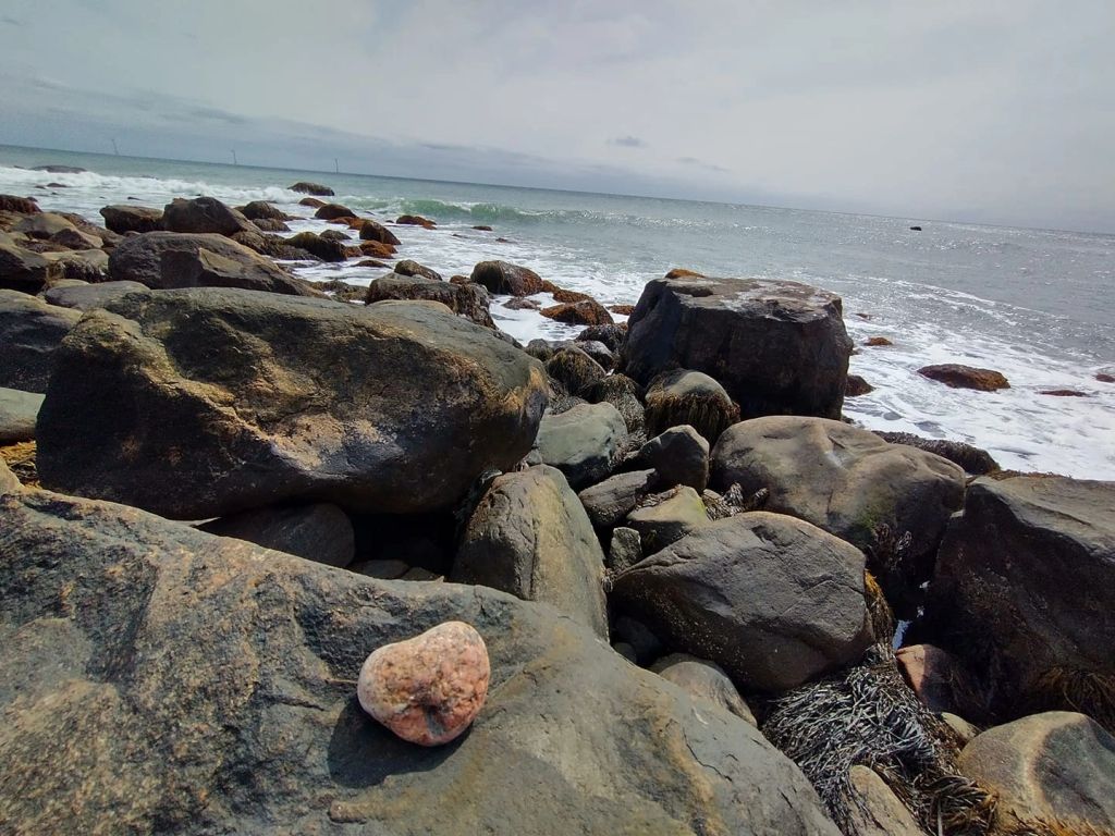 Wellness stones on rocky shore representing balance and grounding