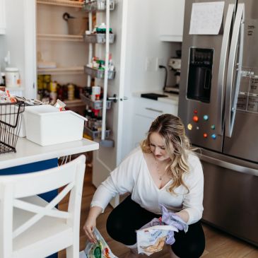 Woman organizing groceries into bins in the kitchen.