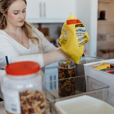Woman pouring food into a container.