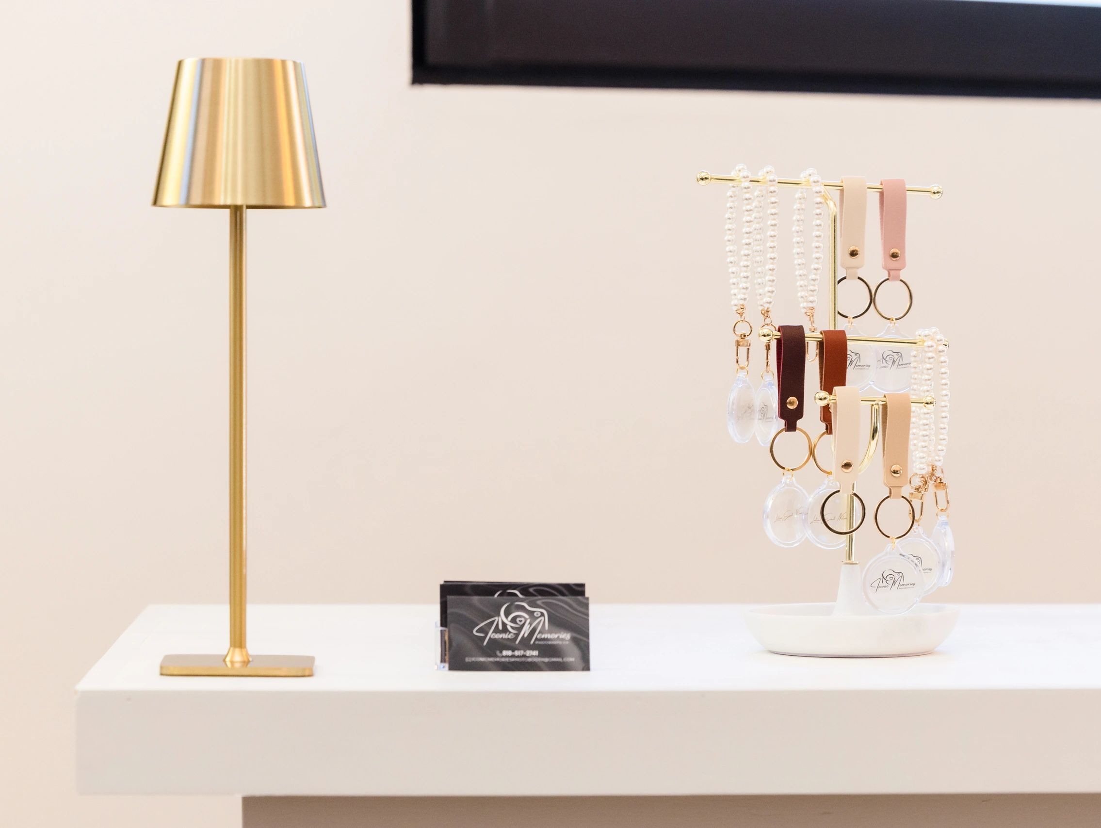 Elegant gold lamp and keychains on a white table.