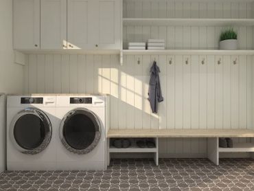 Bright, organized laundry room with washer, dryer, hooks, and shelves.