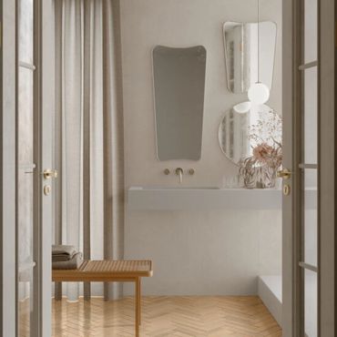 Minimalist bathroom with unique mirrors and wooden bench.
