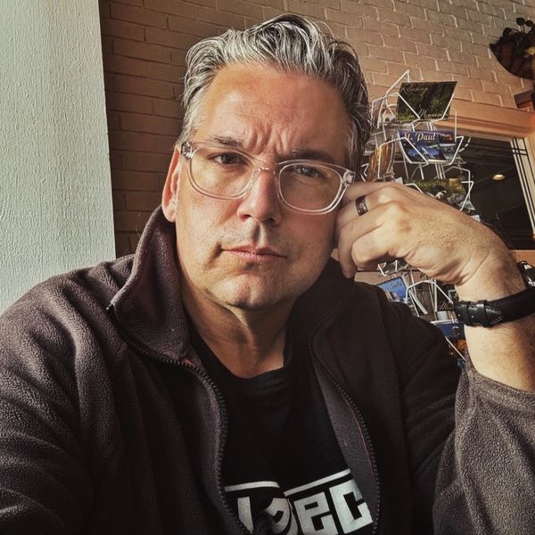 Man with gray hair and glasses looking at the camera.