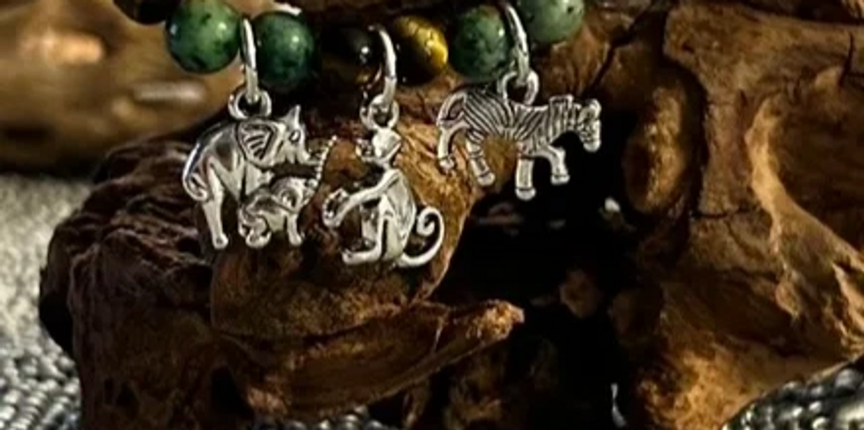 Bracelet with silver animal charms featuring an elephant, monkey, and zebra.