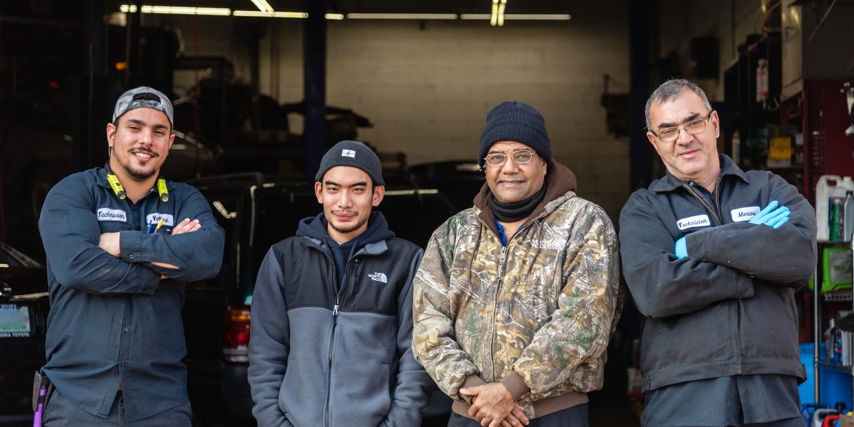 Four men standing together posing for a group photo