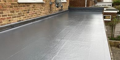 Newly coated flat roof with smooth grey waterproofing.