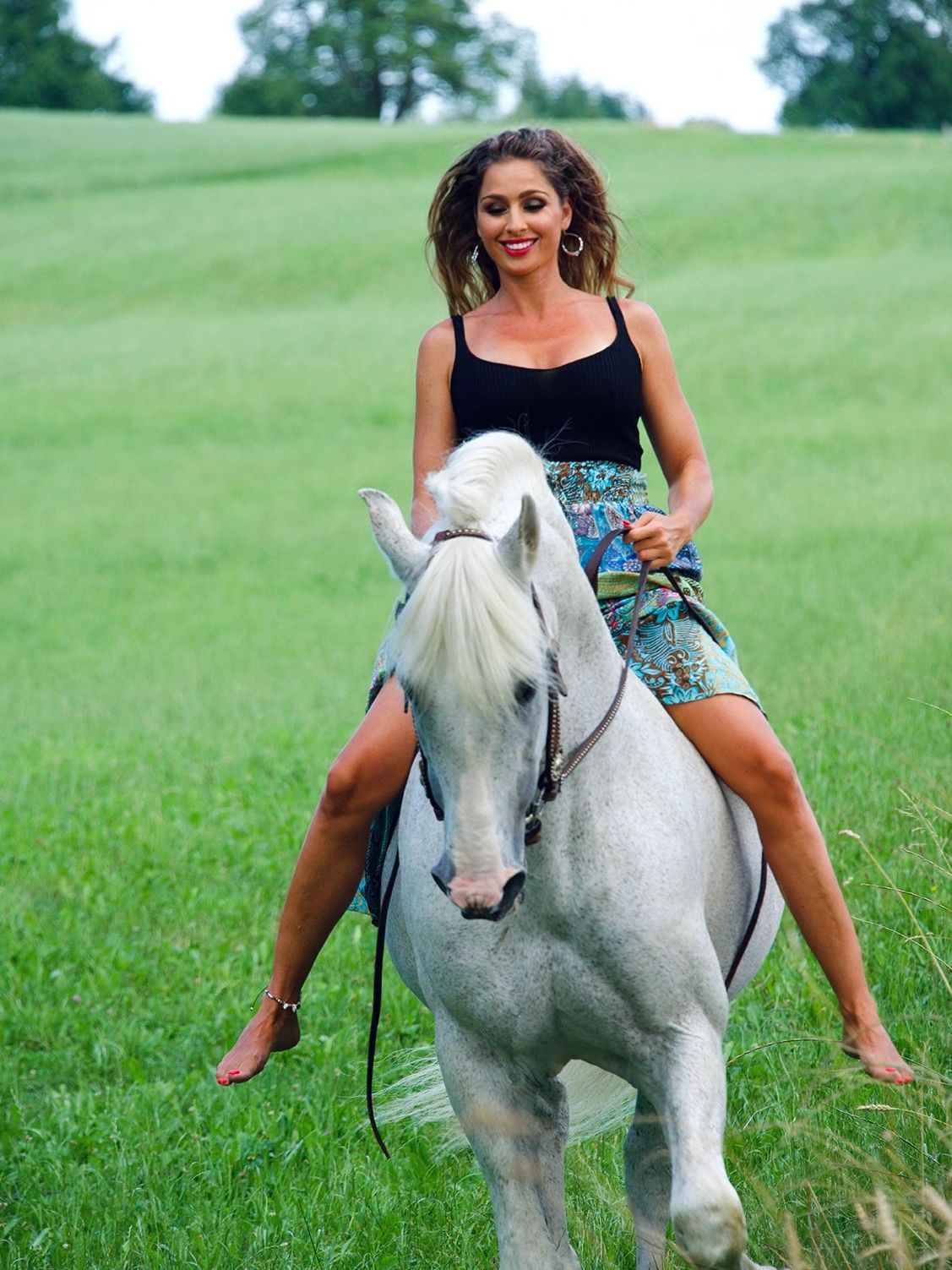 Lachende Frau auf weissem Hengst, Andalusier, PRE, Pferd mit Frau galoppiert über grünes Feld
