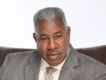 Portrait of a confident man in a gray suit and tie.