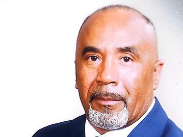 Portrait of a middle-aged man in a suit with a trimmed beard.