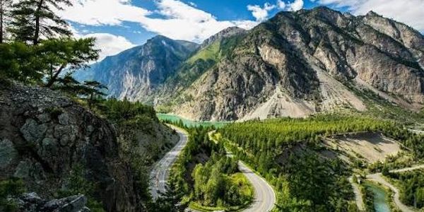 Mountain road winding through a forested valley.