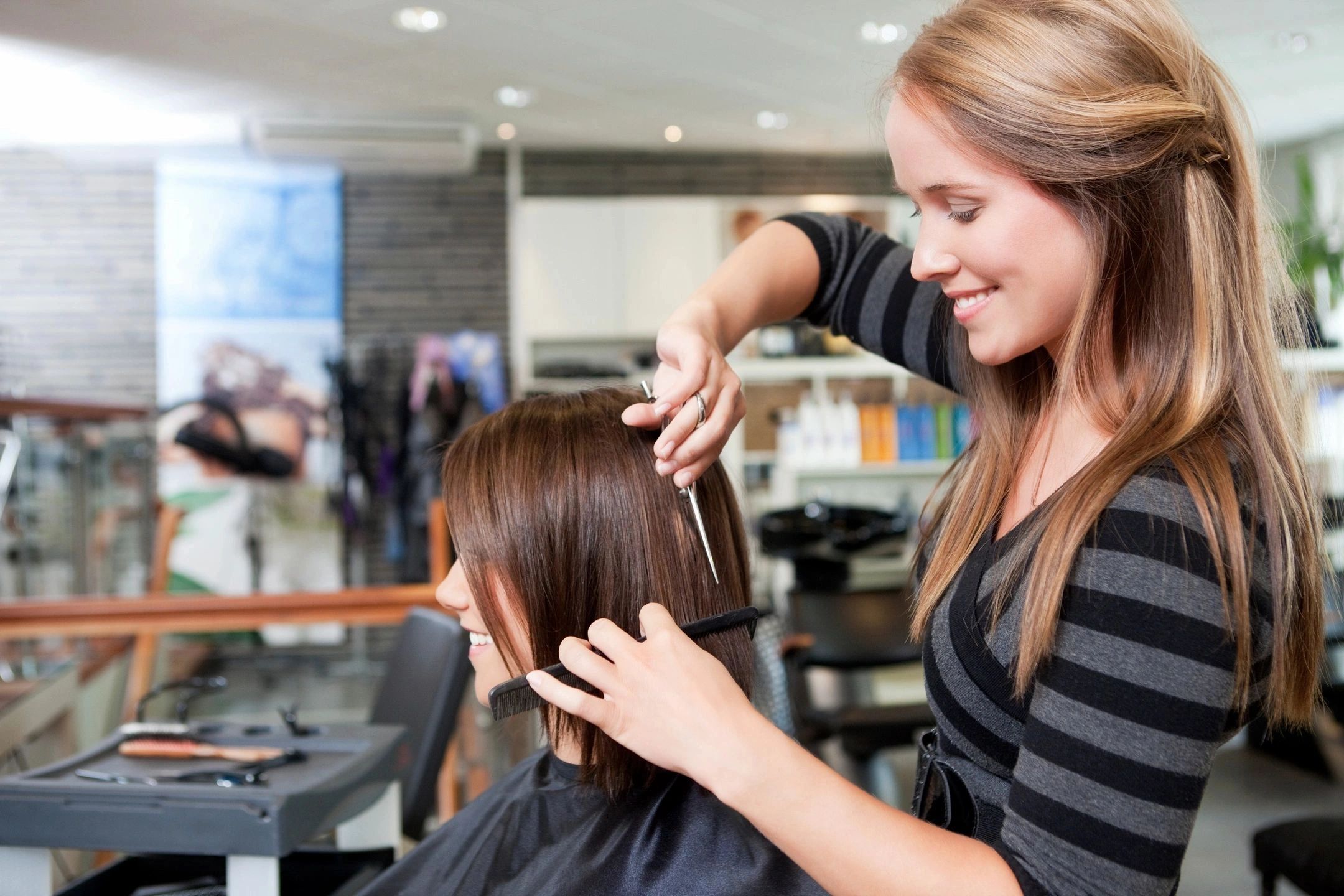 Hairdresser cutting client's hair in beauty salon