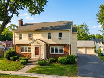 Two-story suburban house with brick and siding exterior and a driveway.