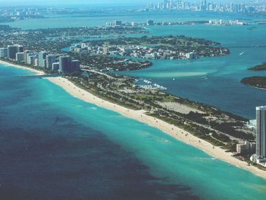 Top view of a city with long buildings and ocean
