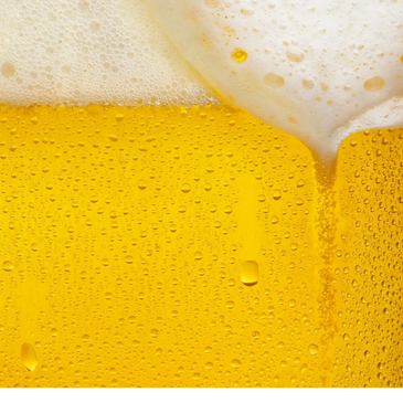 Close-up of a cold beer with bubbles and foam.