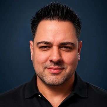 Portrait of a confident man with styled hair and a slight smile.