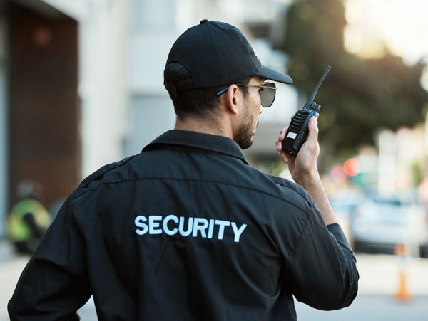 Radio, man and a security guard or safety officer outdoor on a city road for communication.