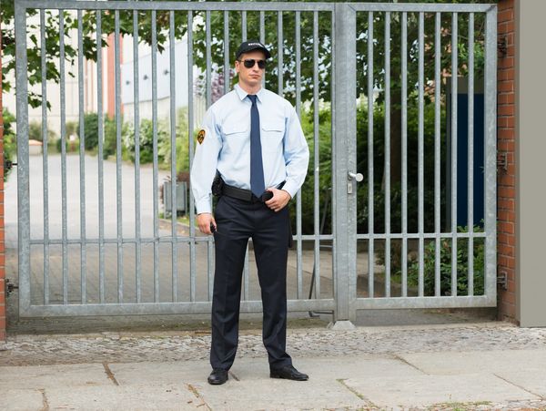 Portrait of Young Male Security Guard Standing At The Entrance