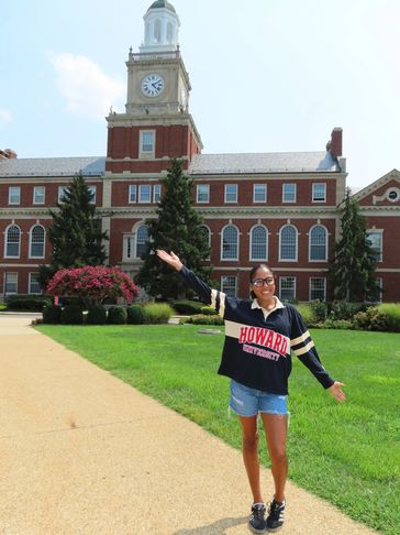 Student posing in front of Howard University building.