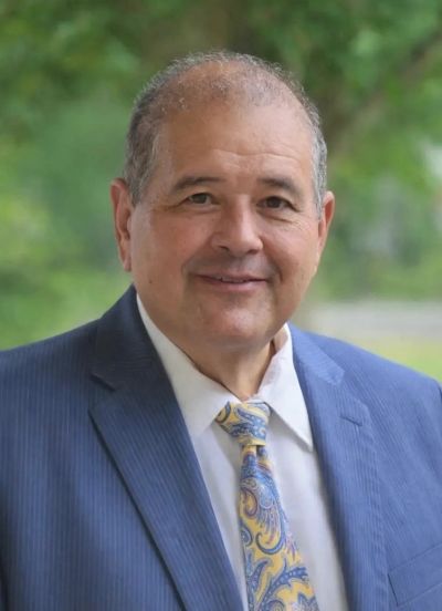 Smiling elderly man in suit outdoors.