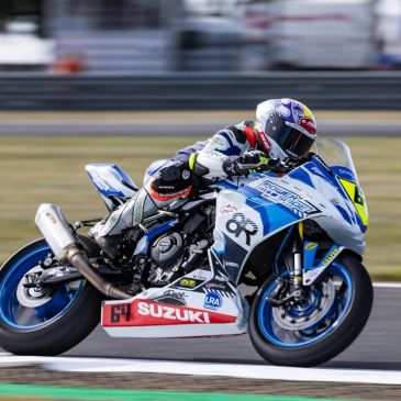 Motorcycle racer riding a Suzuki bike on a track.