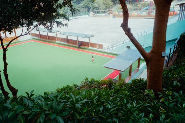 Empty outdoor sports fields with a single person walking.