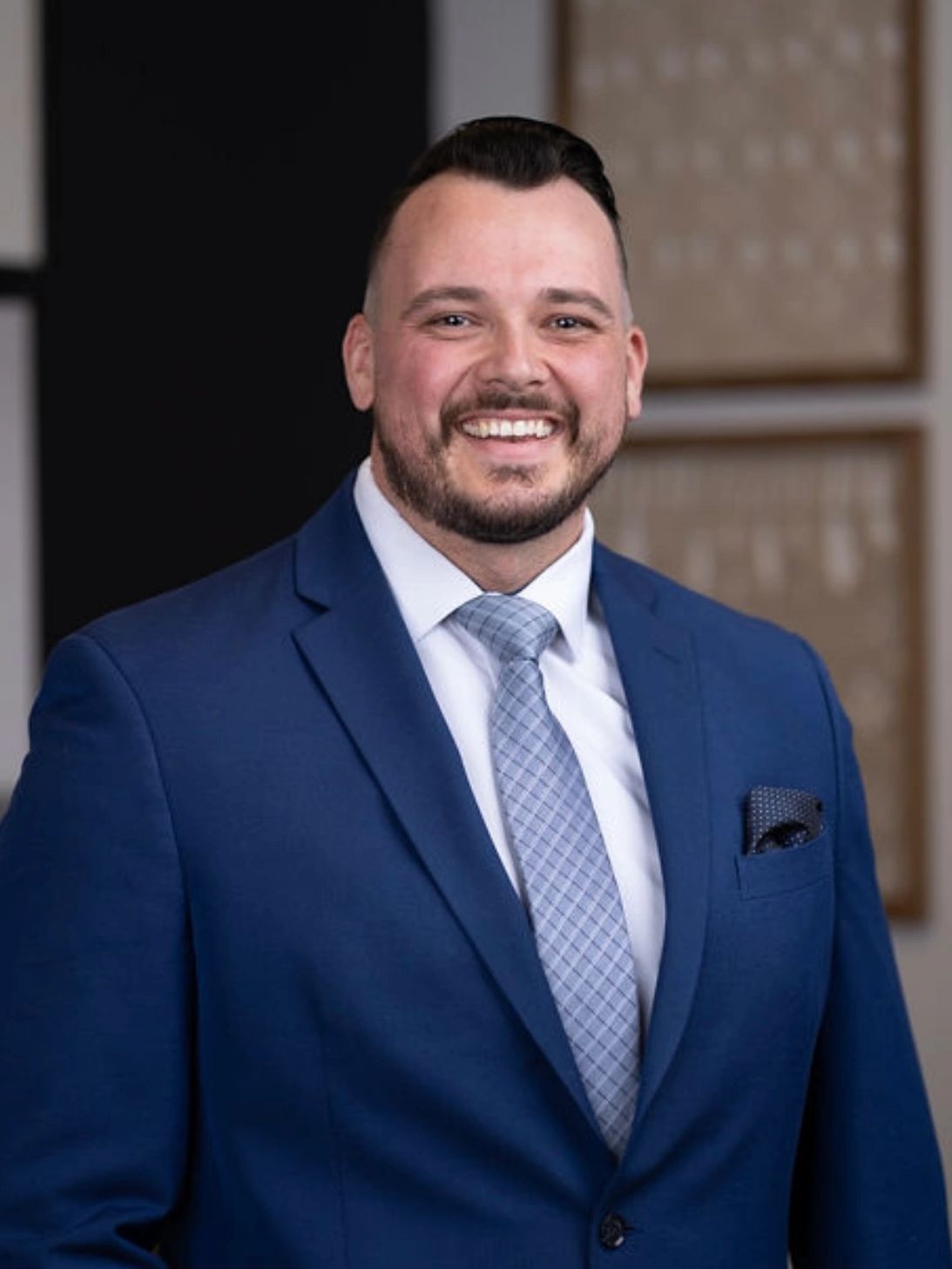 Smiling man in a blue suit and tie.