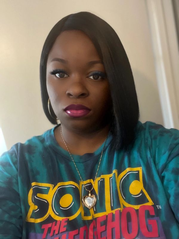 Woman wearing a Sonic the Hedgehog shirt and heart necklace.