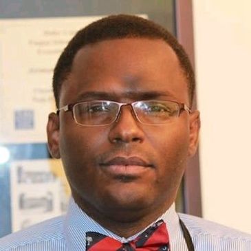 A man wearing glasses and a red bow tie.