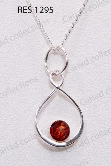 Elegant silver pendant necklace with a red gemstone centerpiece.