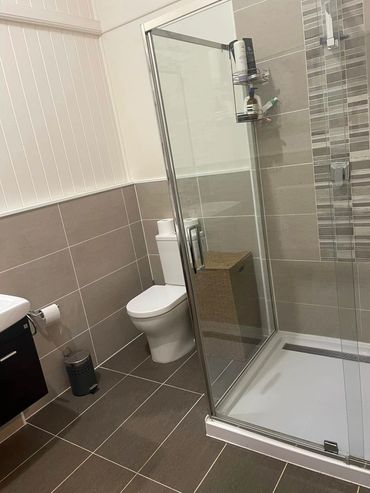 Modern bathroom with glass shower and neutral tones.