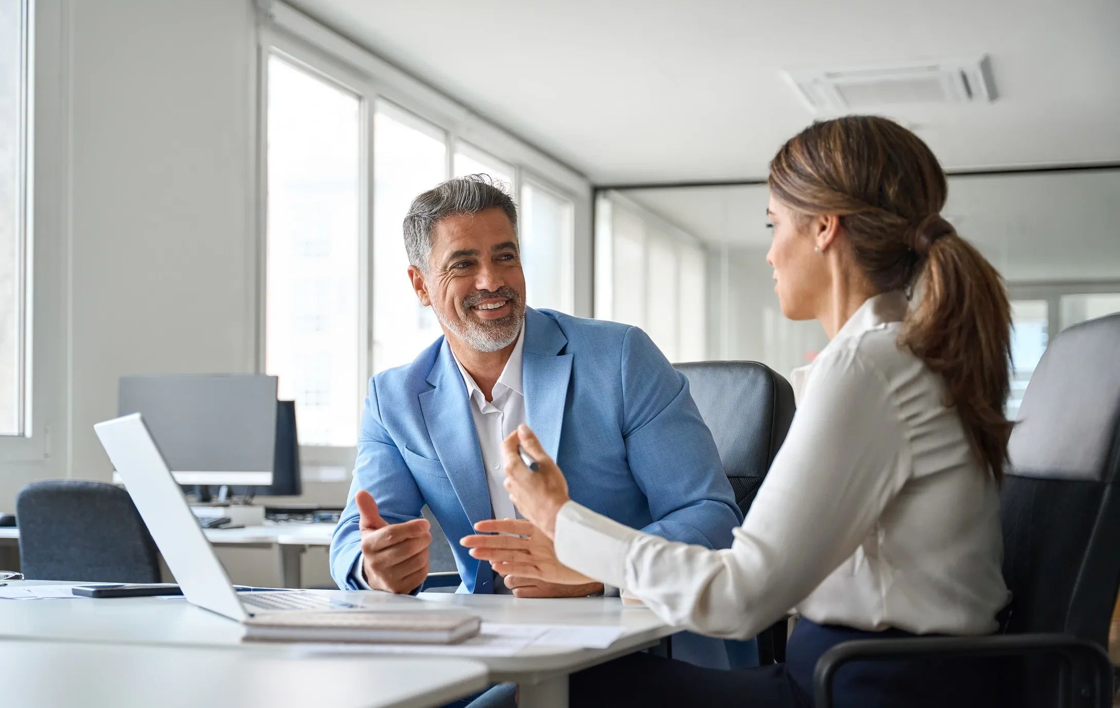 Two professionals engaged in a friendly office discussion.