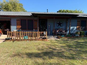 Blue house with wooden shutters and a welcoming front porch.