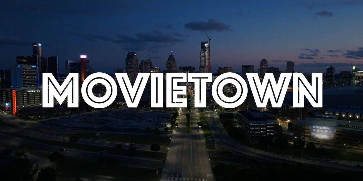 City skyline at night with bold MOVIETOWN text overlay.