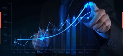 Businessman pointing at a rising digital graph showing growth.